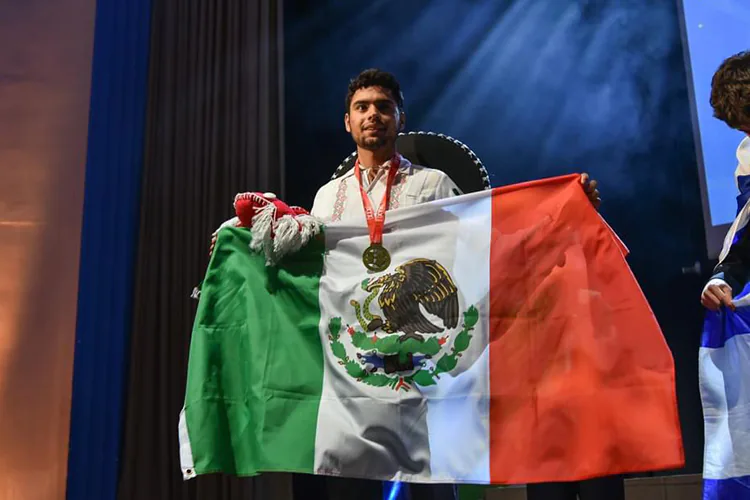 Uno de los jóvenes que ganó en la Olimpiada Internacional de Matemáticas 2024, mientras sostiene una bandera mexicana